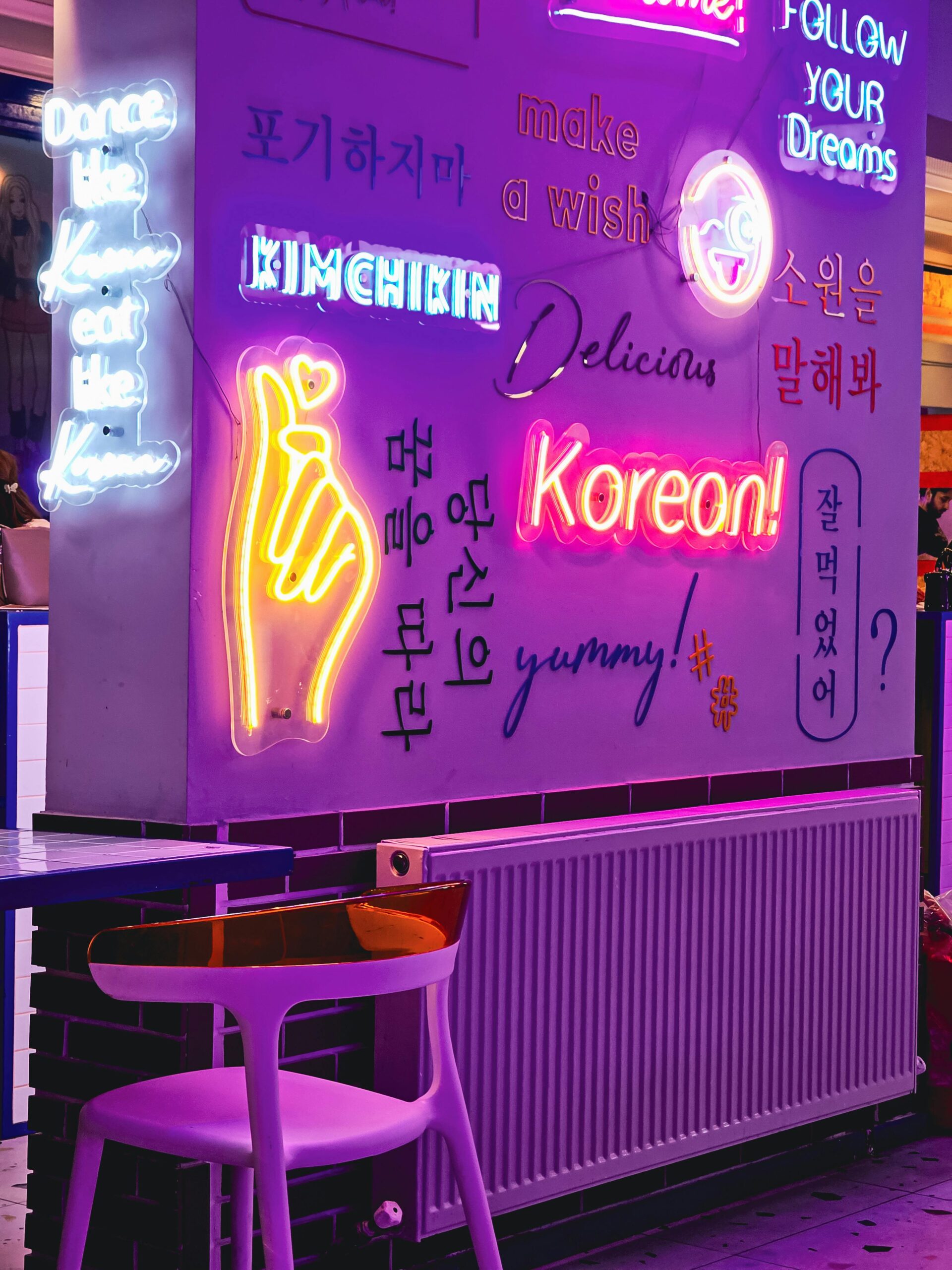 Colorful neon signs in a trendy Korean cafe, exuding a vibrant and modern atmosphere.